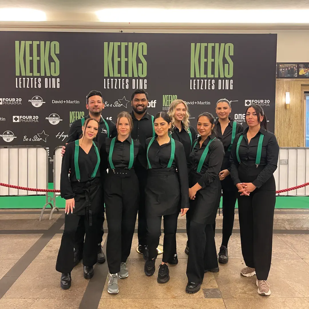 Mitarbeiterteam von Easy Bar and Eventservice posiert vor Fotowand beim KEKS "Letztes Ding" Event